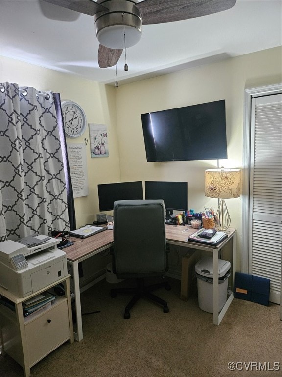 carpeted office space featuring ceiling fan