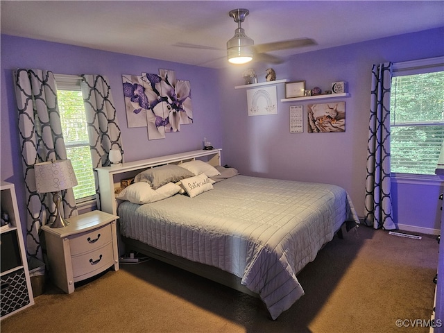 carpeted bedroom featuring ceiling fan and multiple windows