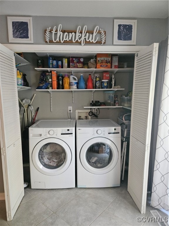 laundry room with light tile patterned floors and washer and clothes dryer