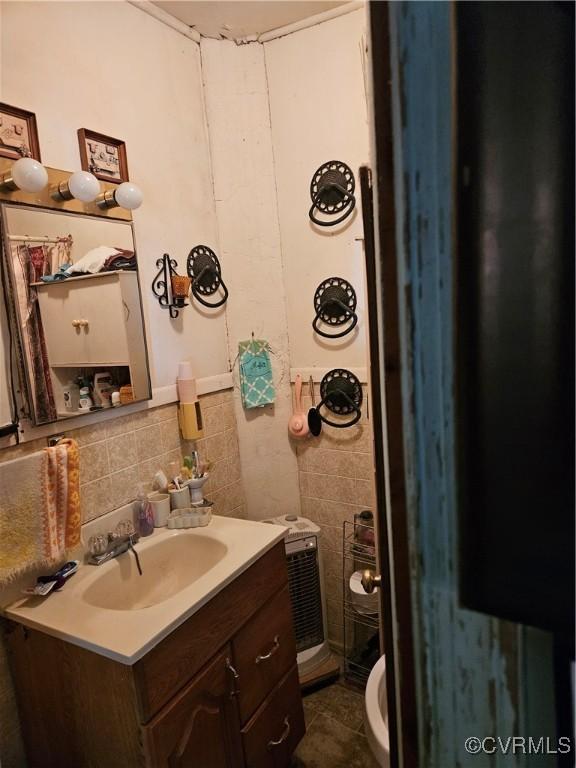 bathroom featuring vanity and tile walls