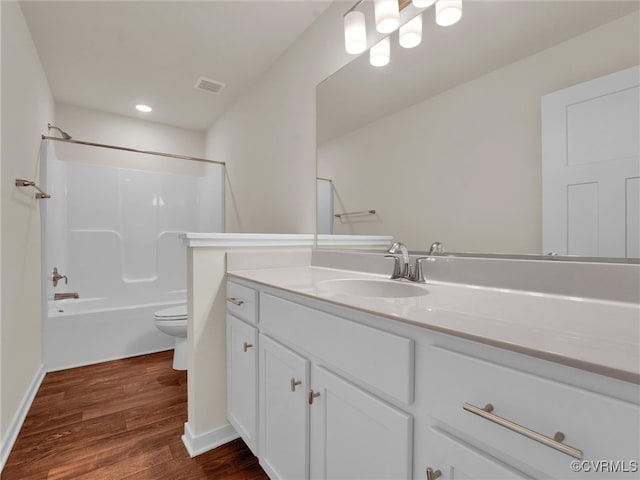 full bathroom with hardwood / wood-style floors, vanity,  shower combination, and toilet