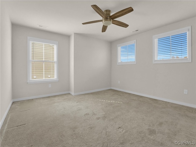 carpeted spare room featuring ceiling fan