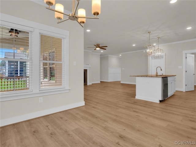 kitchen featuring ornamental molding, ceiling fan with notable chandelier, decorative light fixtures, light hardwood / wood-style flooring, and white cabinets