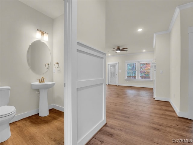 bathroom with hardwood / wood-style flooring, toilet, ceiling fan, and ornamental molding