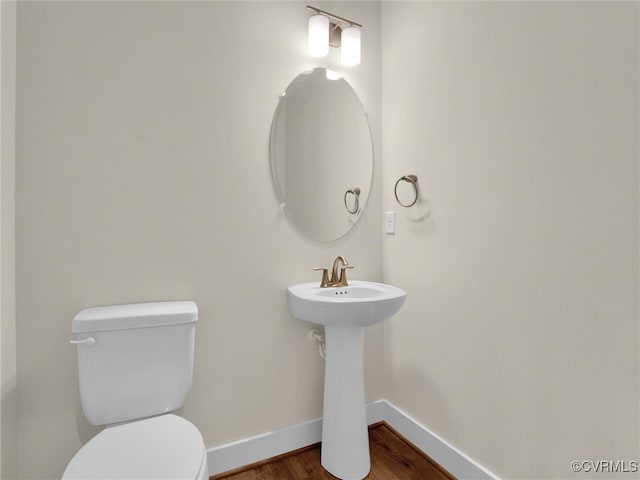 bathroom with wood-type flooring, toilet, and sink