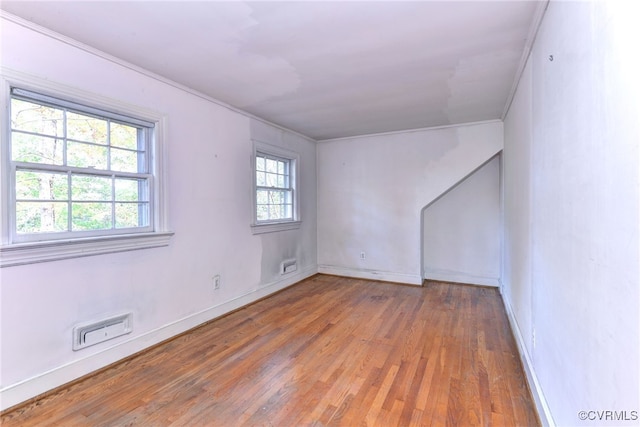 empty room featuring ornamental molding and hardwood / wood-style floors