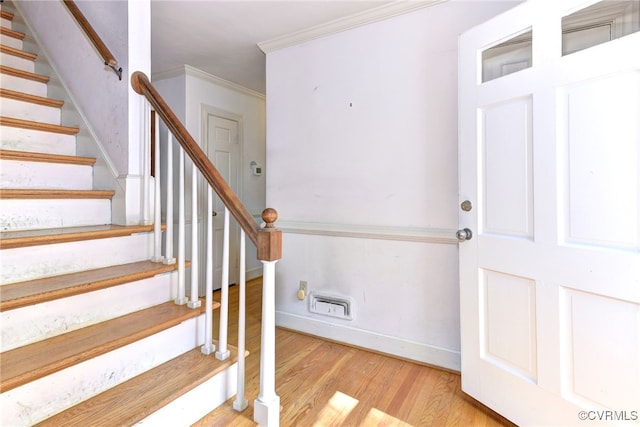 stairway featuring ornamental molding and hardwood / wood-style floors