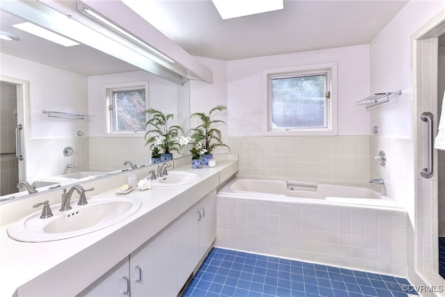 bathroom featuring vanity, tile patterned floors, and tiled bath