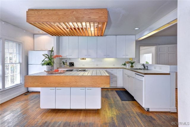 kitchen featuring a kitchen island, white cabinetry, dark wood-type flooring, sink, and white appliances