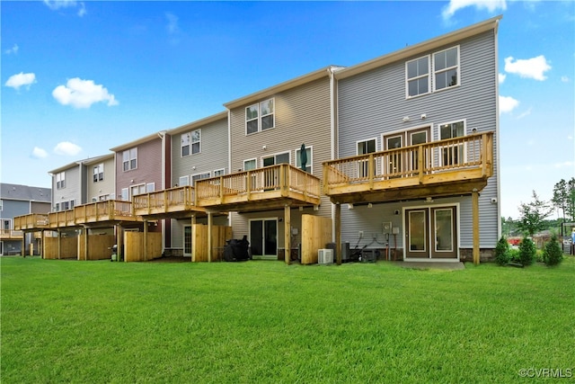 rear view of property with a deck, central air condition unit, and a lawn