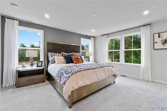 carpeted bedroom featuring multiple windows