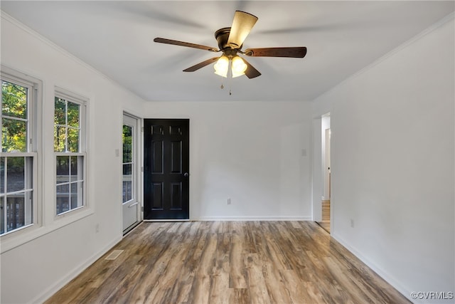 empty room featuring crown molding, hardwood / wood-style floors, and ceiling fan