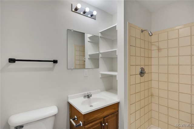 bathroom featuring vanity, toilet, and tiled shower