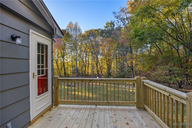 wooden deck featuring a lawn