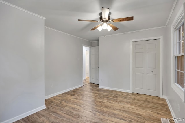 unfurnished bedroom featuring a closet, ceiling fan, hardwood / wood-style flooring, and crown molding