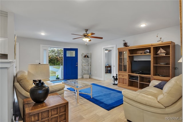 living room featuring light hardwood / wood-style flooring and ceiling fan