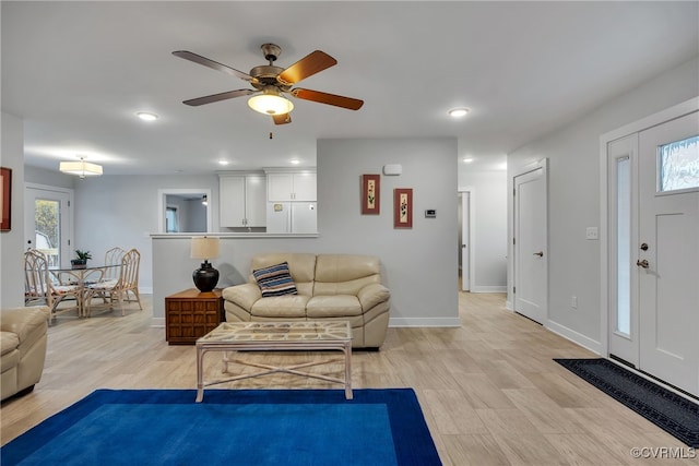 living room featuring ceiling fan and light hardwood / wood-style flooring