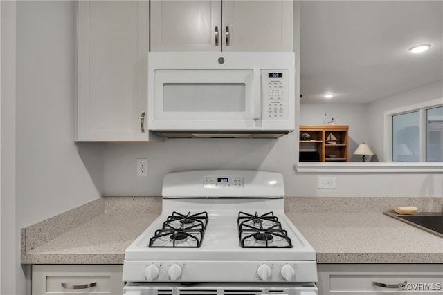 kitchen featuring white cabinets and white appliances