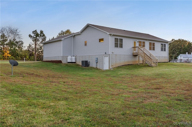 rear view of property with a yard and central AC unit