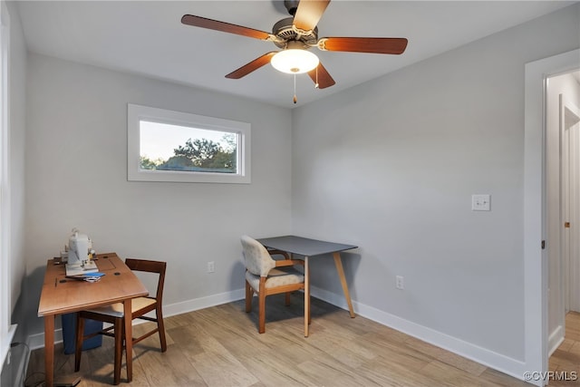 office with light wood-type flooring and ceiling fan