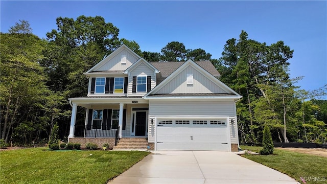 2050 Swiss Ln, Hayes, VA 23072 - view of front of home with covered porch, driveway, board and batten siding, a front lawn, and a garage