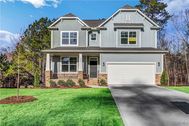 craftsman inspired home featuring a garage, a front yard, and a porch