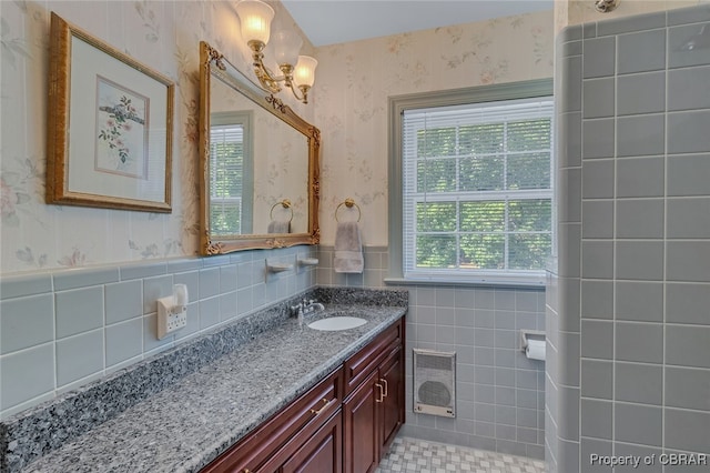 bathroom with vanity, heating unit, and tile walls