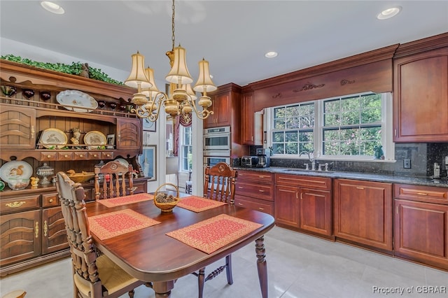 tiled dining room with sink and an inviting chandelier