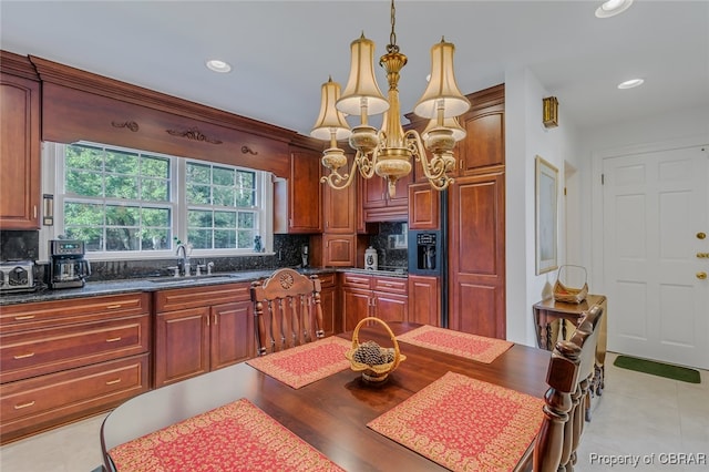 kitchen with a notable chandelier, light hardwood / wood-style flooring, tasteful backsplash, and sink