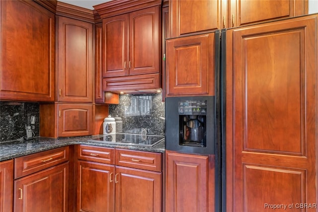 kitchen featuring dark stone countertops, tasteful backsplash, and black cooktop