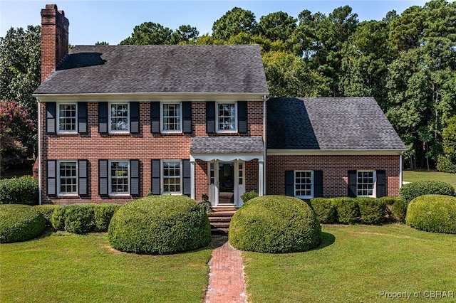 colonial inspired home with a front lawn