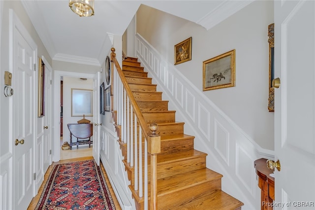 stairs featuring ornamental molding and hardwood / wood-style floors