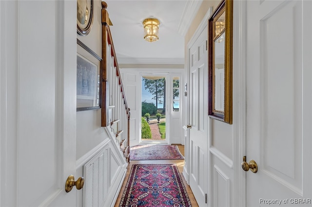 entryway with crown molding and hardwood / wood-style floors