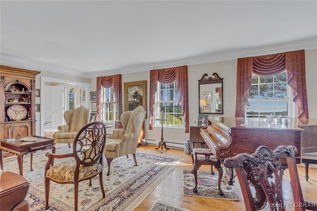 living area with baseboard heating, ornamental molding, light wood-type flooring, and plenty of natural light