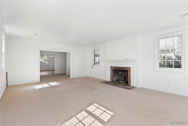 unfurnished living room featuring a brick fireplace, ornamental molding, light colored carpet, and a wealth of natural light