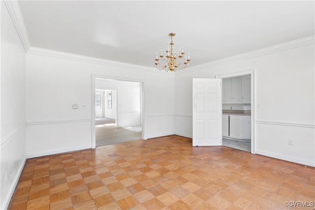 empty room with light parquet flooring, ornamental molding, and an inviting chandelier