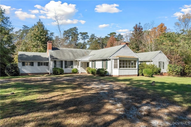 view of front facade featuring a sunroom and a front lawn