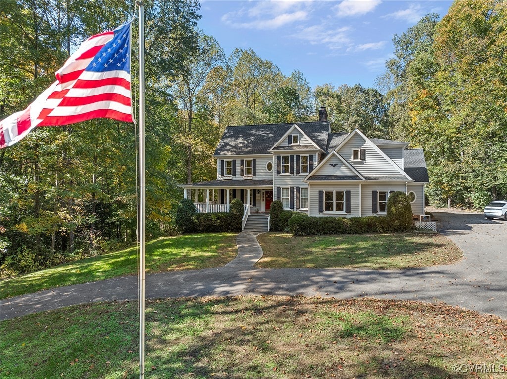 view of front of home with covered porch and a front lawn