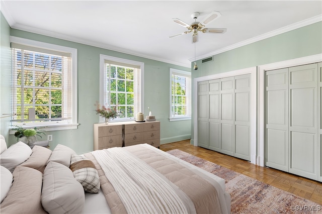 bedroom featuring ceiling fan, multiple closets, multiple windows, and light parquet flooring