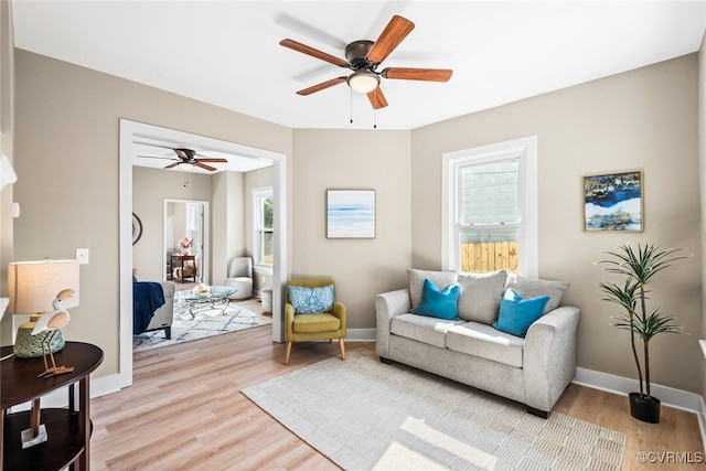 living area with ceiling fan and light hardwood / wood-style flooring