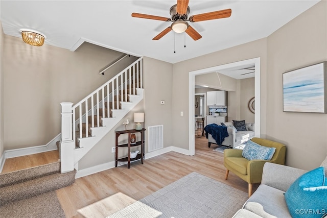 living room with ceiling fan and light hardwood / wood-style flooring