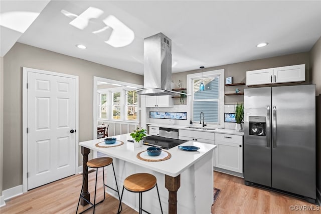 kitchen with white cabinets, sink, hanging light fixtures, island range hood, and stainless steel fridge with ice dispenser