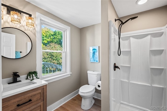 bathroom with a shower, wood-type flooring, vanity, and toilet