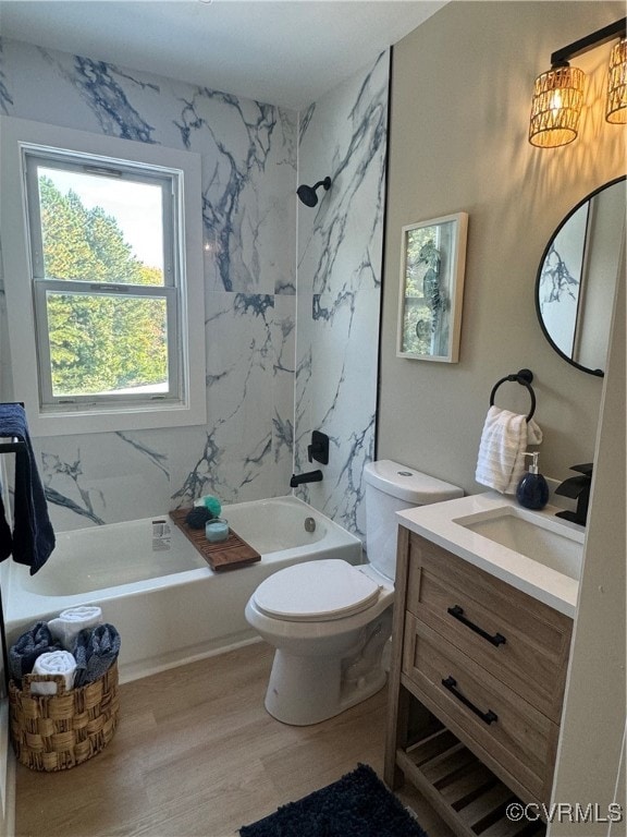 full bathroom featuring hardwood / wood-style floors, vanity, toilet, and tiled shower / bath