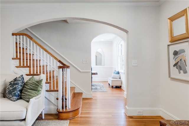 staircase featuring ornamental molding and hardwood / wood-style flooring