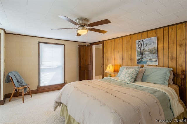 bedroom with multiple windows, wooden walls, crown molding, and ceiling fan