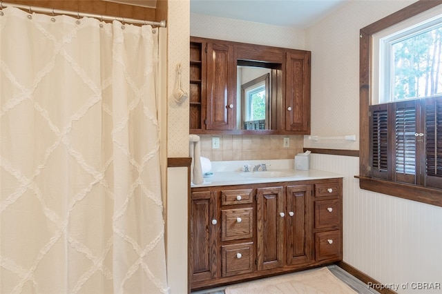 bathroom featuring vanity, wooden walls, and a wealth of natural light