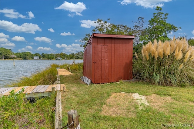 view of outbuilding with a lawn and a water view