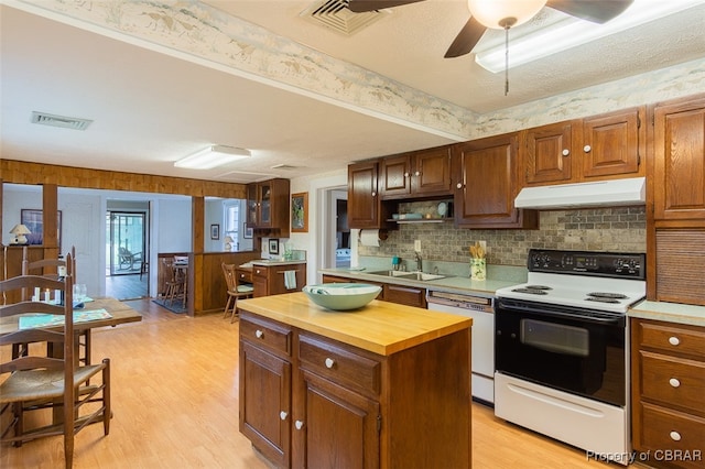 kitchen with white appliances, light wood-type flooring, wood counters, a center island, and ceiling fan