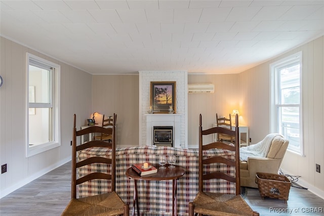 sitting room featuring a wall unit AC, a brick fireplace, and dark hardwood / wood-style floors